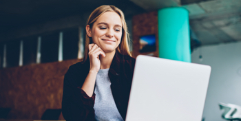 mujer rubia sonriendo al ordenador