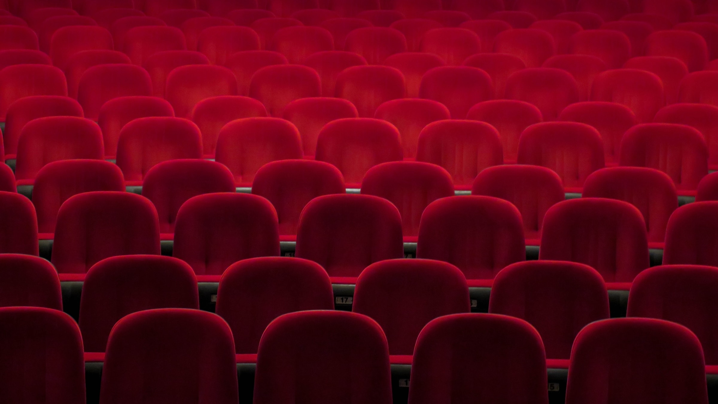 Sala de cine vacía con butacas rojas