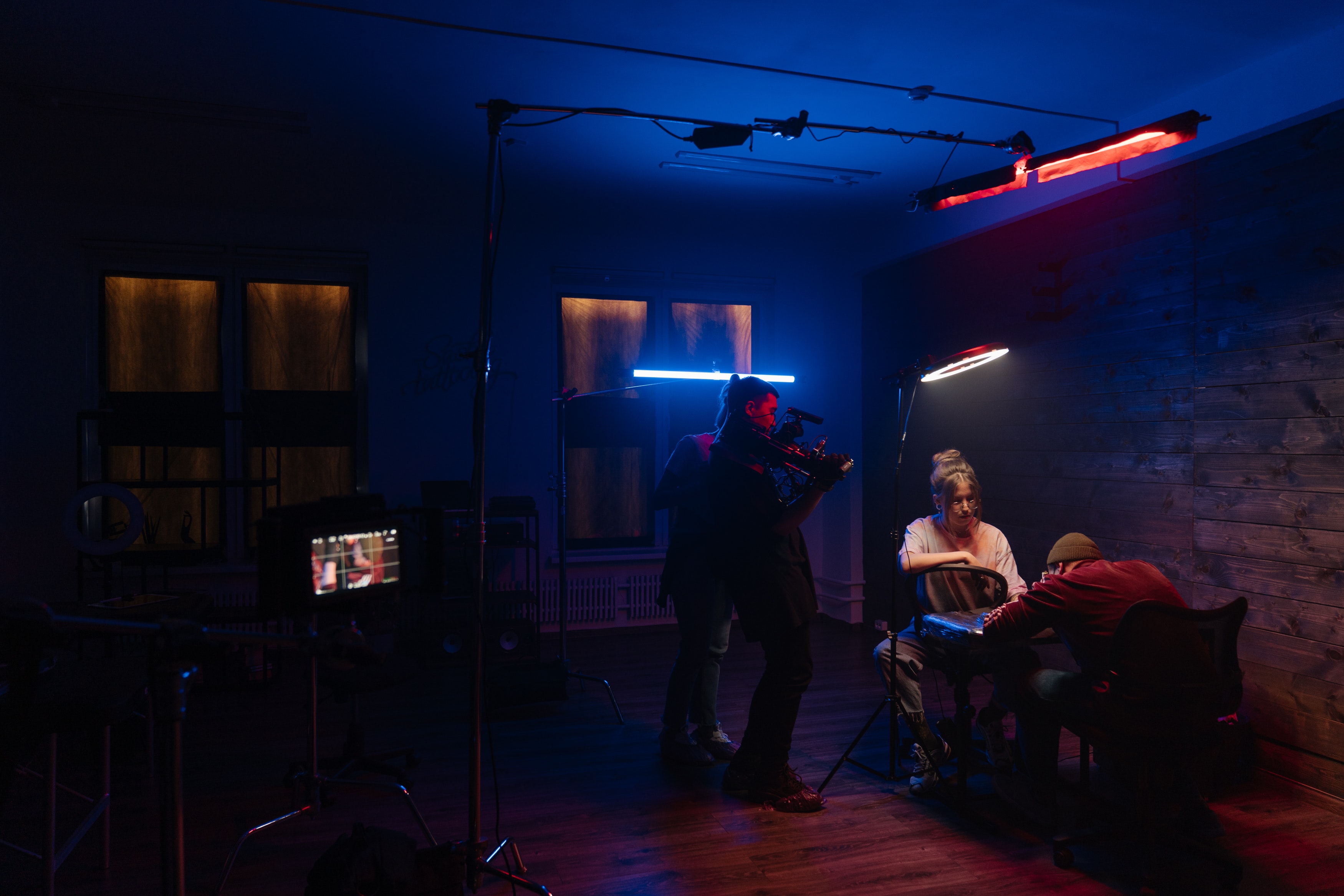 Cámara rodando escena de dos personas sentadas en una habitación con poca luz